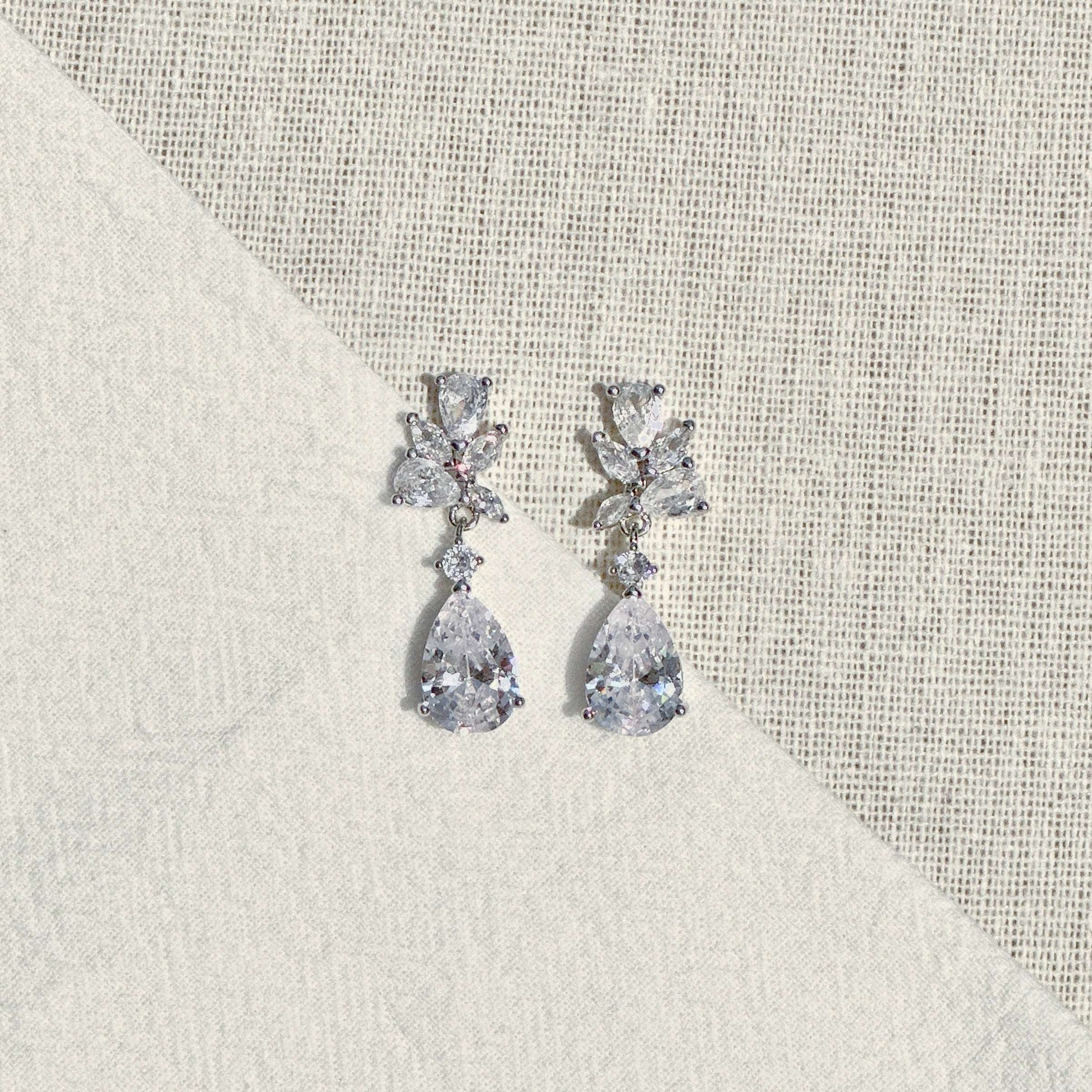 Close-up of EVIE floral cluster and pear-shaped CZ crystal earrings