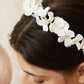 Model wearing the matching delicate pearl and porcelain floral bridal headband