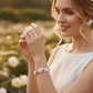 Bride wearing floral bridal jewelry set with flower earrings, pearl hair vine and matching bracelet for garden wedding