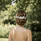 Bride wearing a white ceramic floral hair comb in an elegant half-up wedding hairstyle.