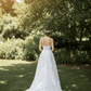 Bride wearing a white ceramic floral hair comb in an elegant half-up wedding hairstyle.