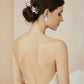 Bride wearing white porcelain flower pearl drop earrings with elegant updo and matching decorative hair pins