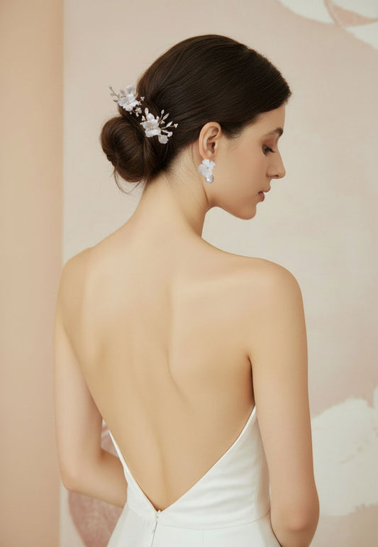 Bride wearing white porcelain flower pearl drop earrings with elegant updo and matching decorative hair pins