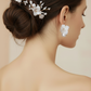 Bride wearing white porcelain flower pearl drop earrings with elegant updo and matching decorative hair pins