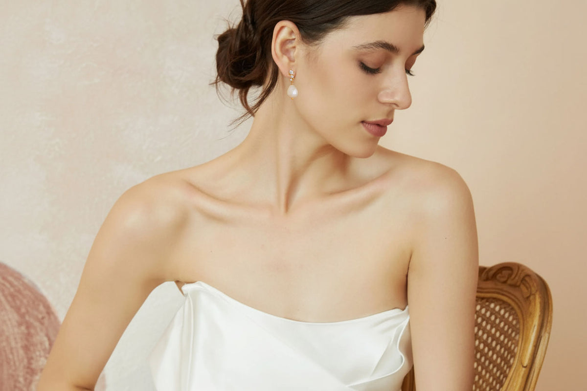 Bride wearing pearl drop earrings - delicate wedding jewelry on model