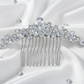 Close-up of a silver bridal hair comb with sparkling rhinestone crystals in a leaf design on a blue background