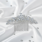 Front view of the sparkling rhinestone leaf hair comb on a blue surface