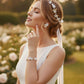 Floral bridal jewelry set with white ceramic flower earrings, gold hair vine and matching bracelet on white background