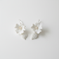 White porcelain flower drop earrings with pearl centre and ceramic leaf drop — bridal jewellery flat lay