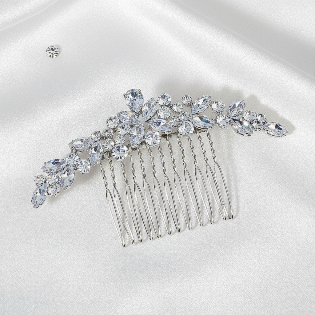 Close-up of a silver bridal hair comb with sparkling rhinestone crystals in a leaf design on a blue background
