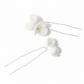 Bride from behind showing white porcelain flower hair pins in twisted bun and matching drop earrings — complete bridal set