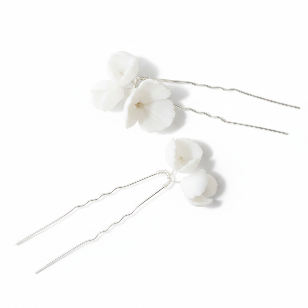 Bride from behind showing white porcelain flower hair pins in twisted bun and matching drop earrings — complete bridal set