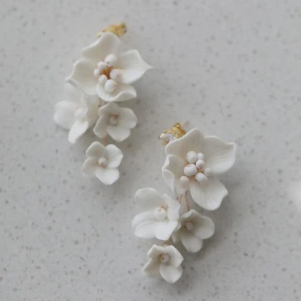 White floral earrings on a light gray background