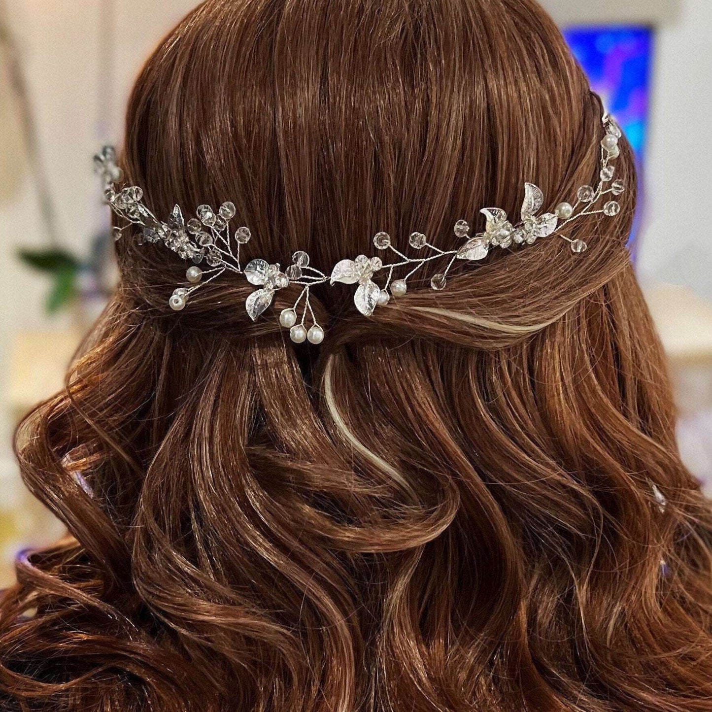 Model with wavy brown hair wearing a silver pearl and crystal hair comb