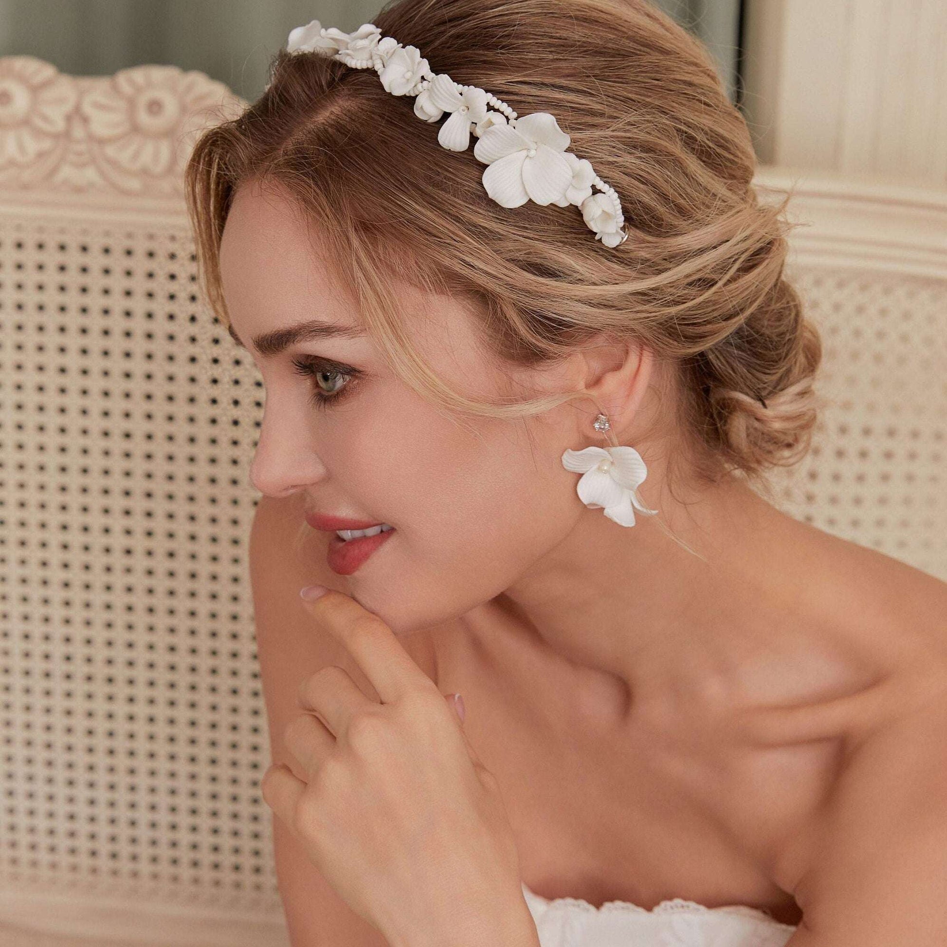 Skillfully handcrafted, these flower bridal earrings are the perfect complement to our signature porcelain headpieces. Each earring is exquisitely made by hand, featuring two delicate white clay flowers adorned with freshwater pearls.