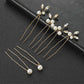 Set of 6 gold wedding hair pins with pearls and crystals arranged on a black background
