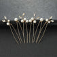 Set of 6 gold wedding hair pins with pearls and crystals arranged on a black background