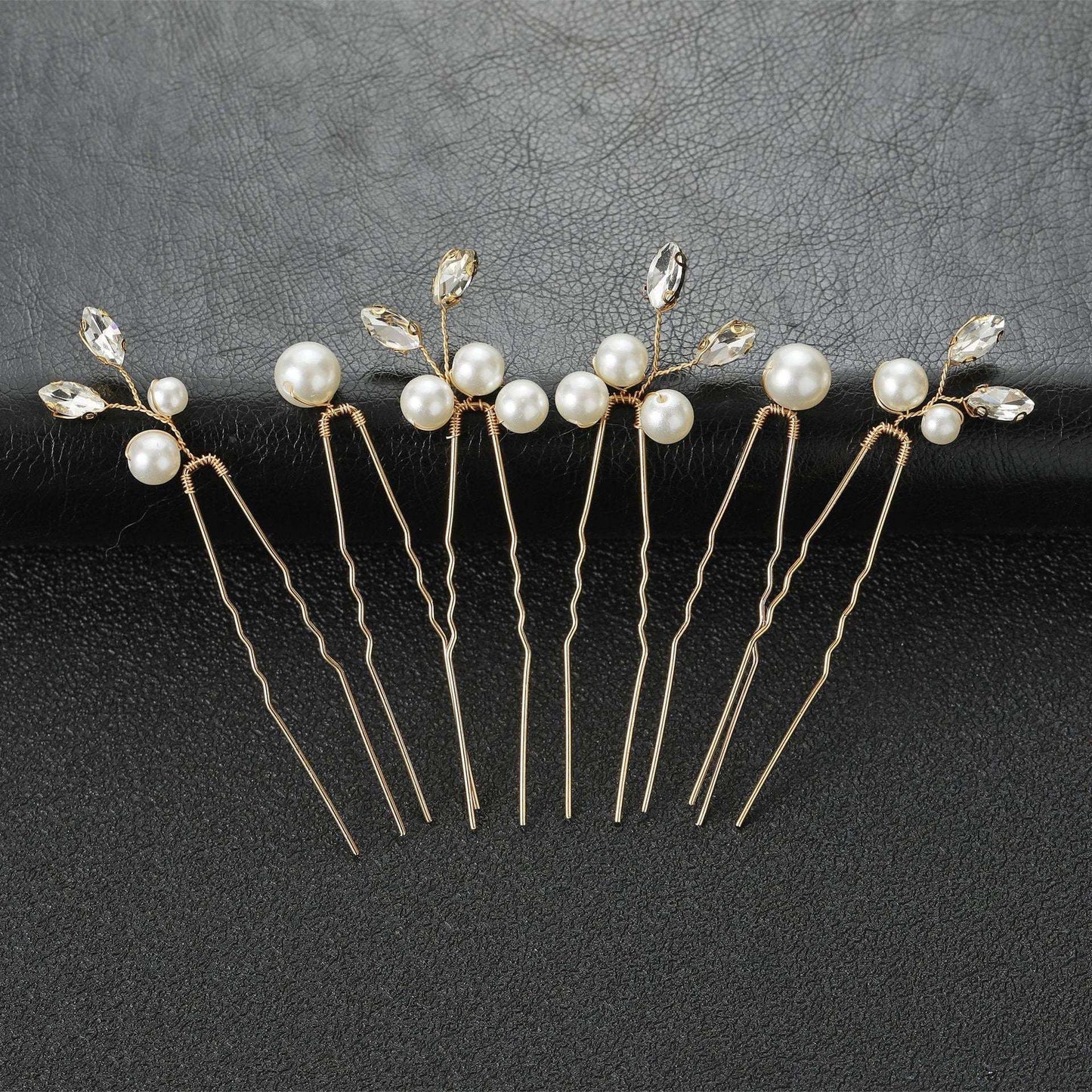 Set of 6 gold wedding hair pins with pearls and crystals arranged on a black background