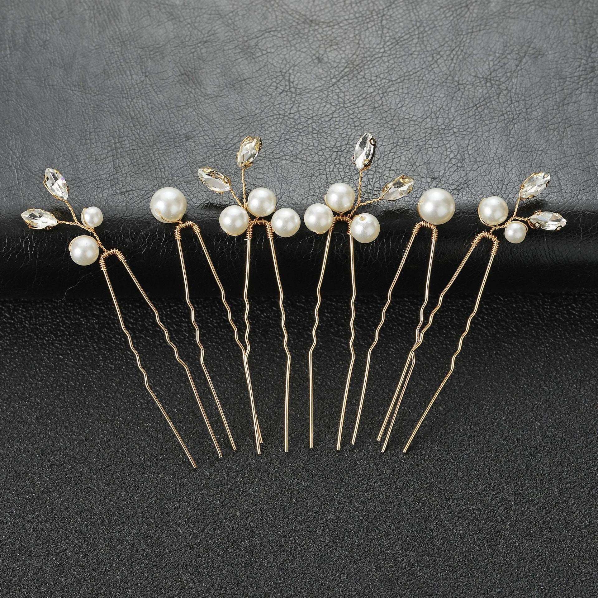 Set of 6 gold wedding hair pins with pearls and crystals arranged on a black background