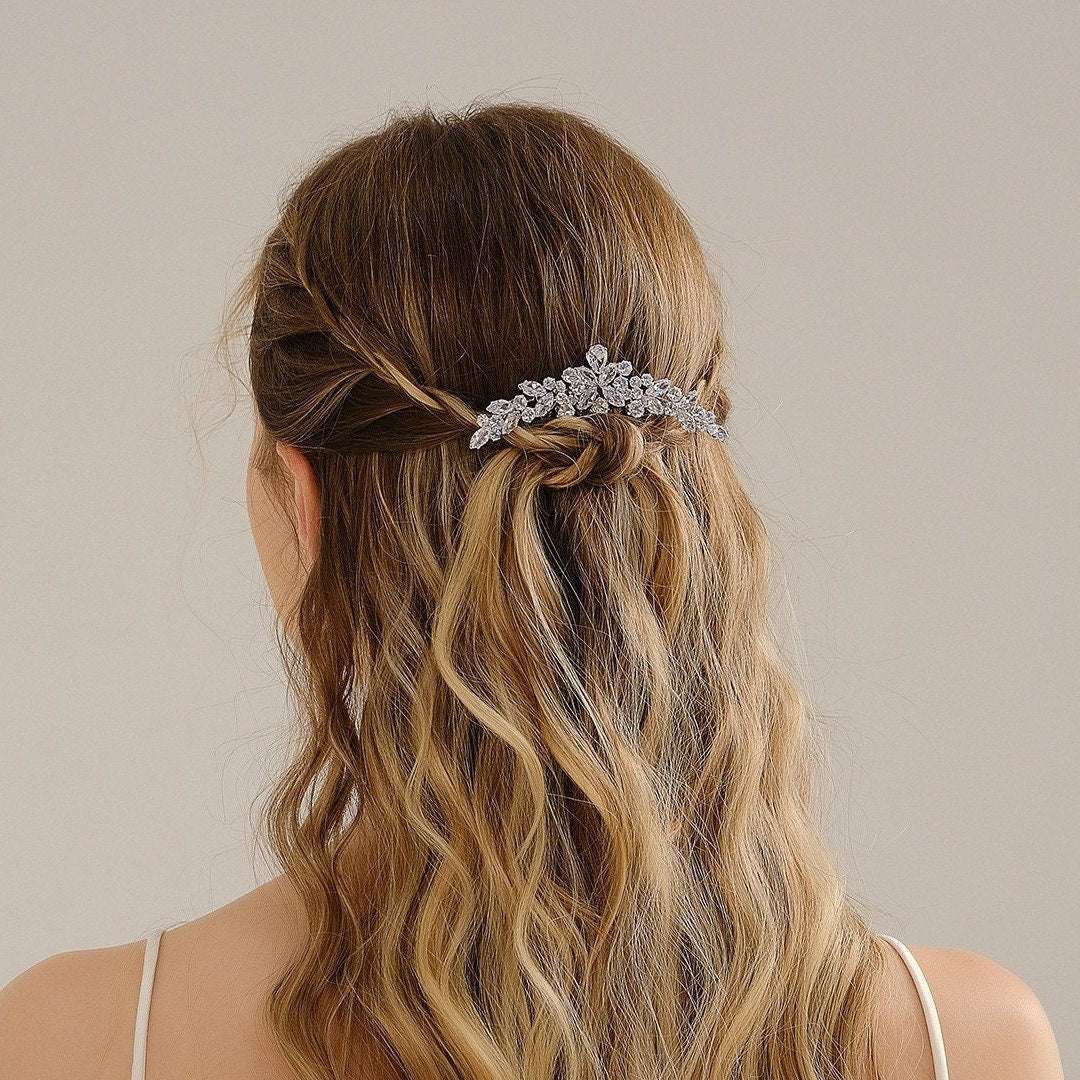 Model with wavy brown hair wearing a silver crystal leaf hair comb in a half-up style
