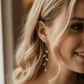 14K gold olive leaf crystal drop earrings worn by bride, elegant bridal styling