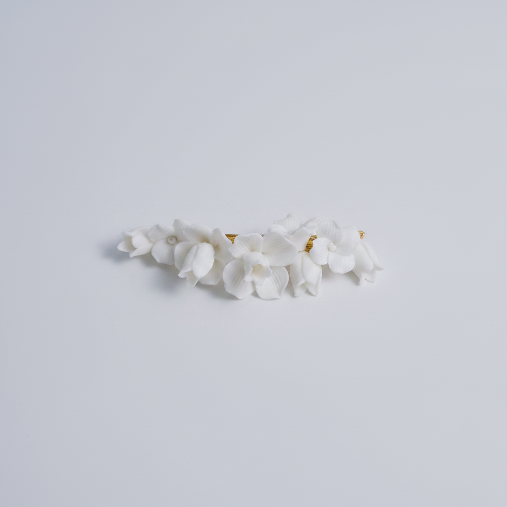 CHARLOTTE white porcelain flower hair clip in gold on a white background