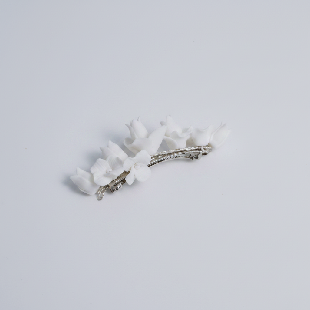 Side view of the CHARLOTTE white porcelain flower hair clip in silver
