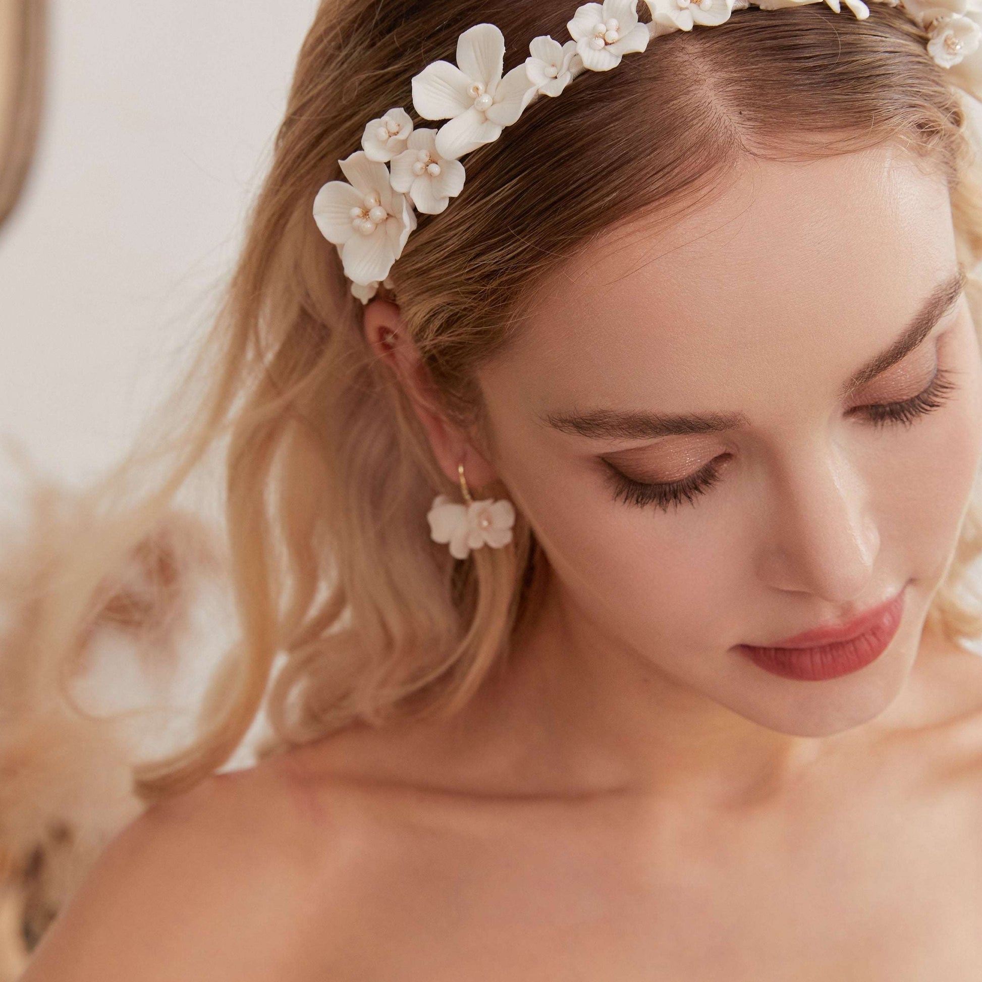 Close-up of LILY delicate floral drop earrings on a model