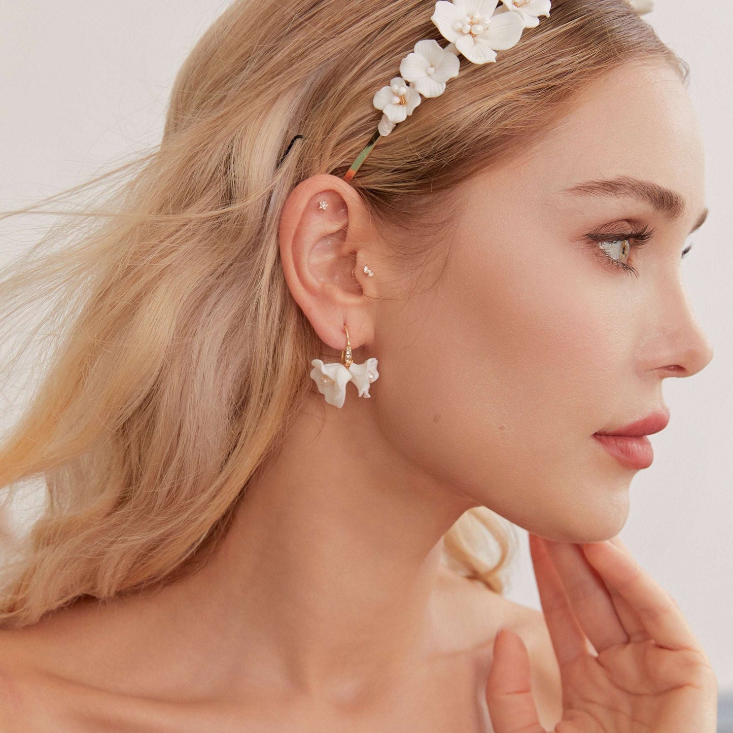 Close-up of LILY delicate floral drop earrings on a model