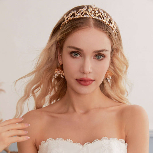 Victoria | Gold Crystal Bridal Crown Tiara - Handcrafted with attention to detail, this unique crown features delicate gold metal leaves intricately arranged alongside an array of dazzling rhinestone flowers in various sizes. The combination of gold and crystals creates a vintage-inspired woodland feel. 