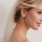 These stunning earrings feature leaf-like zirconia crystals that shimmer beneath three delicate pearls, evoking the graceful beauty of blooming flowers.