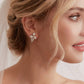 These stunning earrings feature leaf-like zirconia crystals that shimmer beneath three delicate pearls, evoking the graceful beauty of blooming flowers.