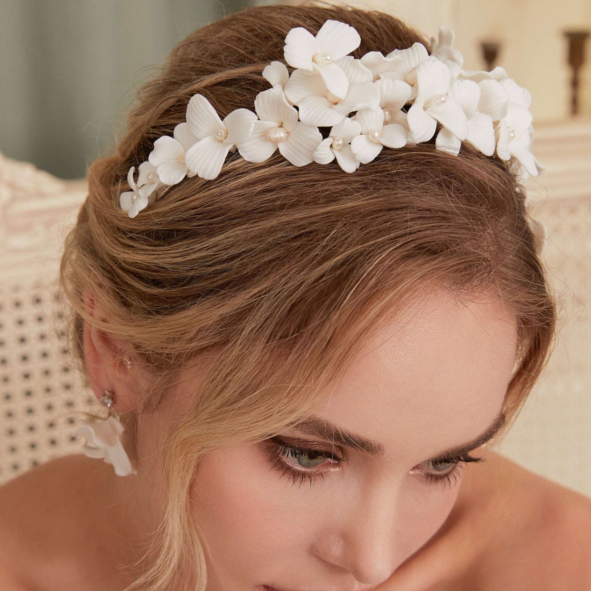 A gloriously romantic hand-sculpted porcelain bridal crown. Made with an arrangement of individually crafted flowers and dainty pearls. This full and textured headband makes a statement but yet still feels incredibly feminine.