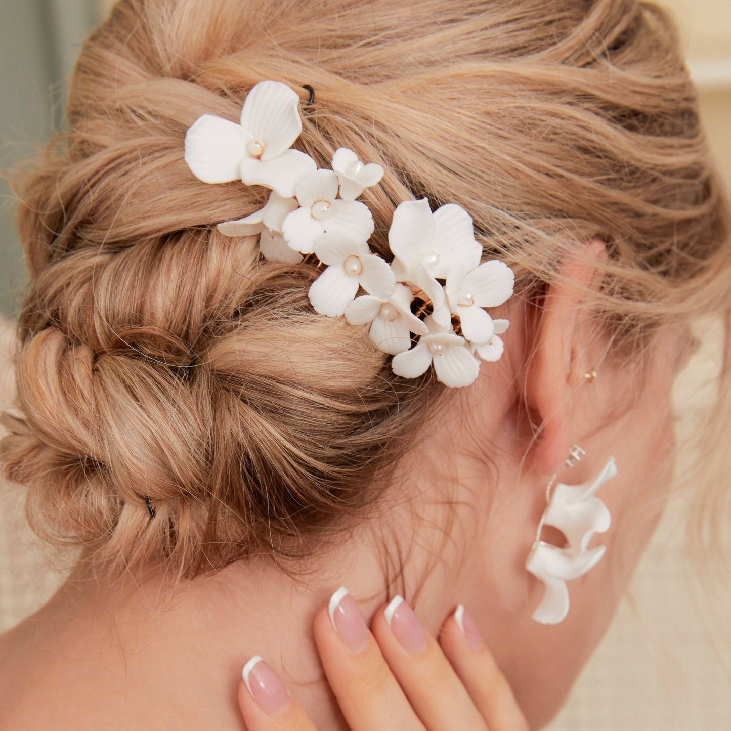 A delicate and romantic white porcelain bridal hair comb, handcrafted with love. This exquisite bridal hairpiece features a cluster of beautiful flowers adorned with lustrous natural freshwater pearls, arranged in a full design.