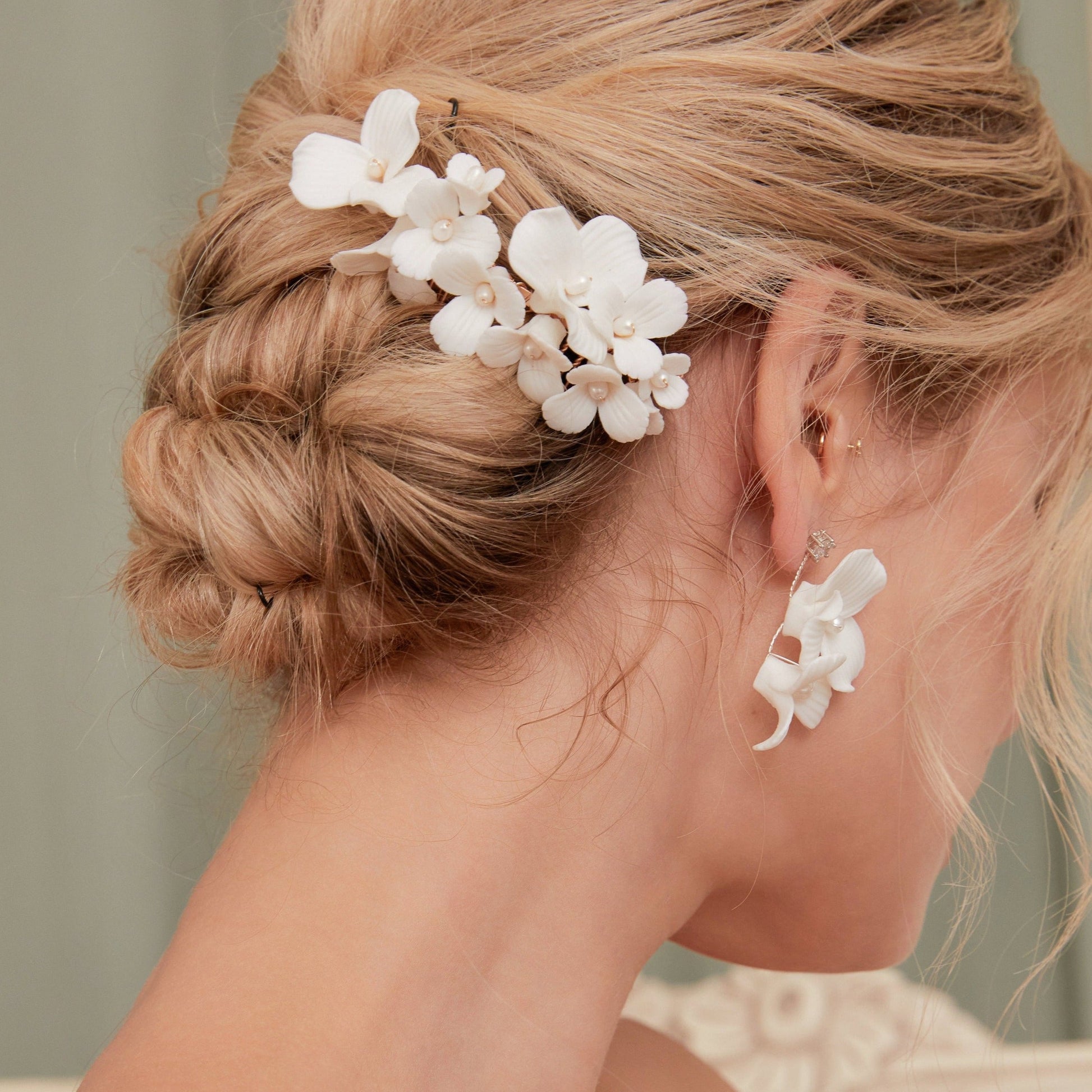 A delicate and romantic white porcelain bridal hair comb, handcrafted with love. This exquisite bridal hairpiece features a cluster of beautiful flowers adorned with lustrous natural freshwater pearls, arranged in a full design.