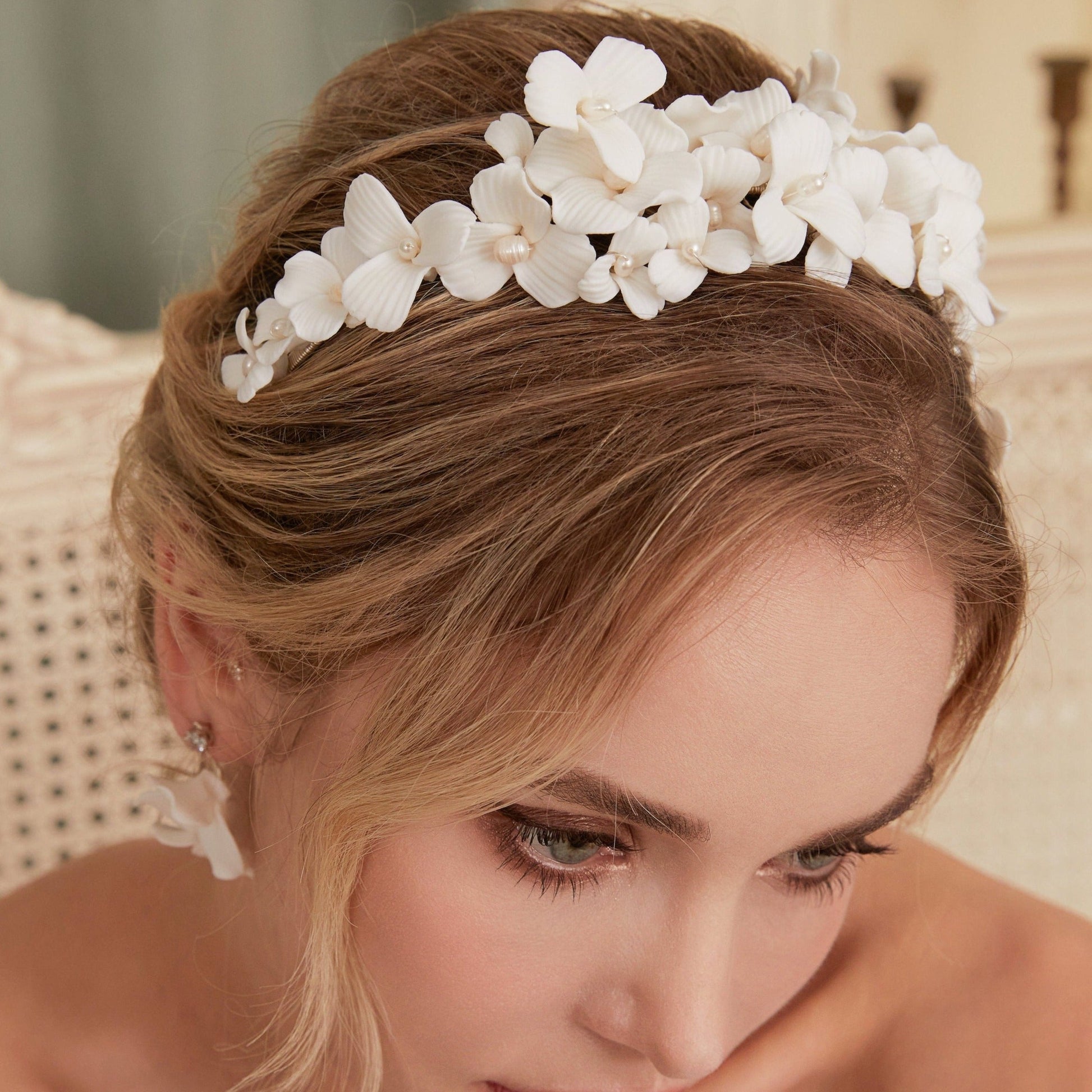 A gloriously romantic hand-sculpted porcelain bridal crown. Made with an arrangement of individually crafted flowers and dainty pearls. This full and textured headband makes a statement but yet still feels incredibly feminine.