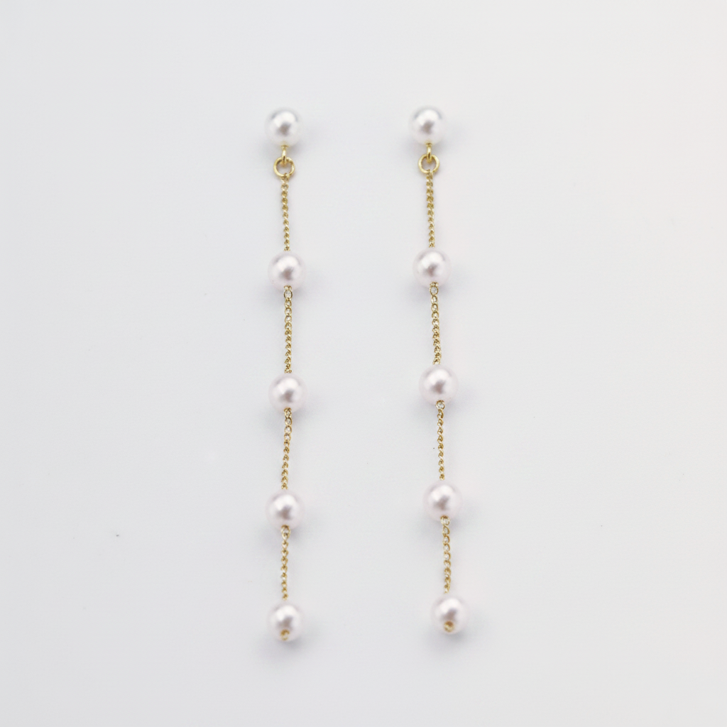 Close-up of a woman wearing delicate pearl threader earrings