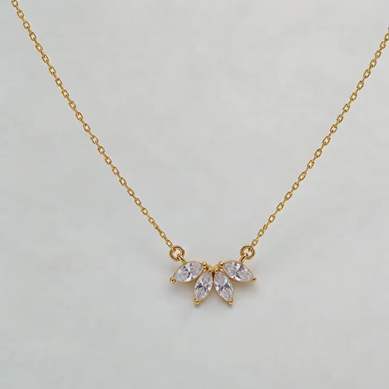 Gold-coloured marquise flower petal CZ necklace displayed on ivory satin