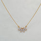 Gold-coloured marquise flower petal CZ necklace displayed on ivory satin