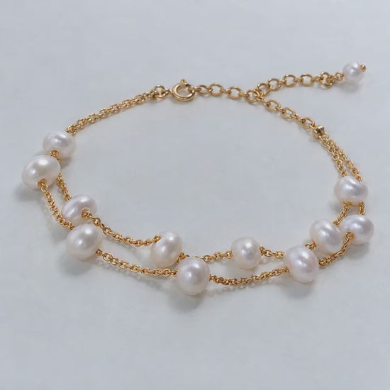 Video close-ups of a double-strand pearl bracelet showing gold chains and an extension chain
