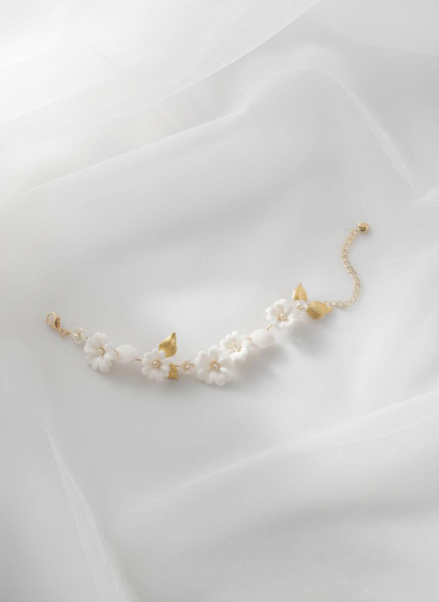 Adjustable floral bracelet with white ceramic blooms and leaf accents, gold chain bridal wrist jewellery
