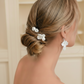 Back view of bride with white ceramic flower hair pins in low chignon updo — bridal hair accessories by PearlandStone