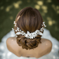 Close up of delicate white porcelain flower petals and lustrous pearl accents on a gold tone bridal hair comb.