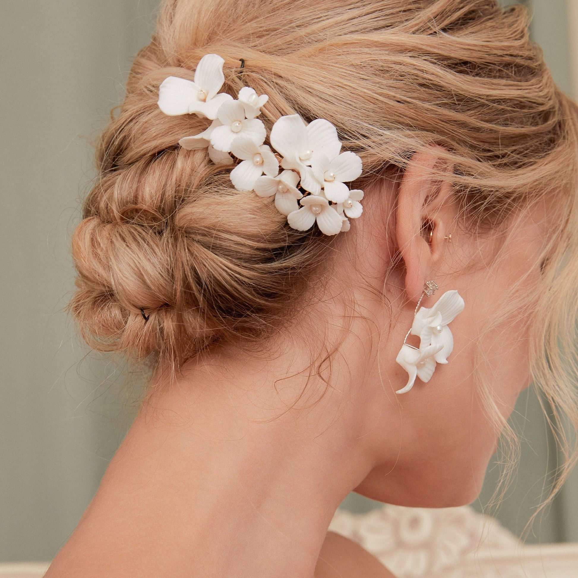 A delicate and romantic white porcelain bridal hair comb, handcrafted with love. This exquisite bridal hairpiece features a cluster of beautiful flowers adorned with lustrous natural freshwater pearls, arranged in a full design.