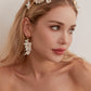 Carefully crafted by hand, these flower bridal earrings are a perfect match to our porcelain headpieces. Each earring features delicate white clay flowers and leaves adorned with shimmering freshwater pearls. These earrings have a long drop design that is sure to catch attention and make a statement.