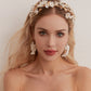 Carefully crafted by hand, these flower bridal earrings are a perfect match to our porcelain headpieces. Each earring features delicate white clay flowers and leaves adorned with shimmering freshwater pearls. These earrings have a long drop design that is sure to catch attention and make a statement.